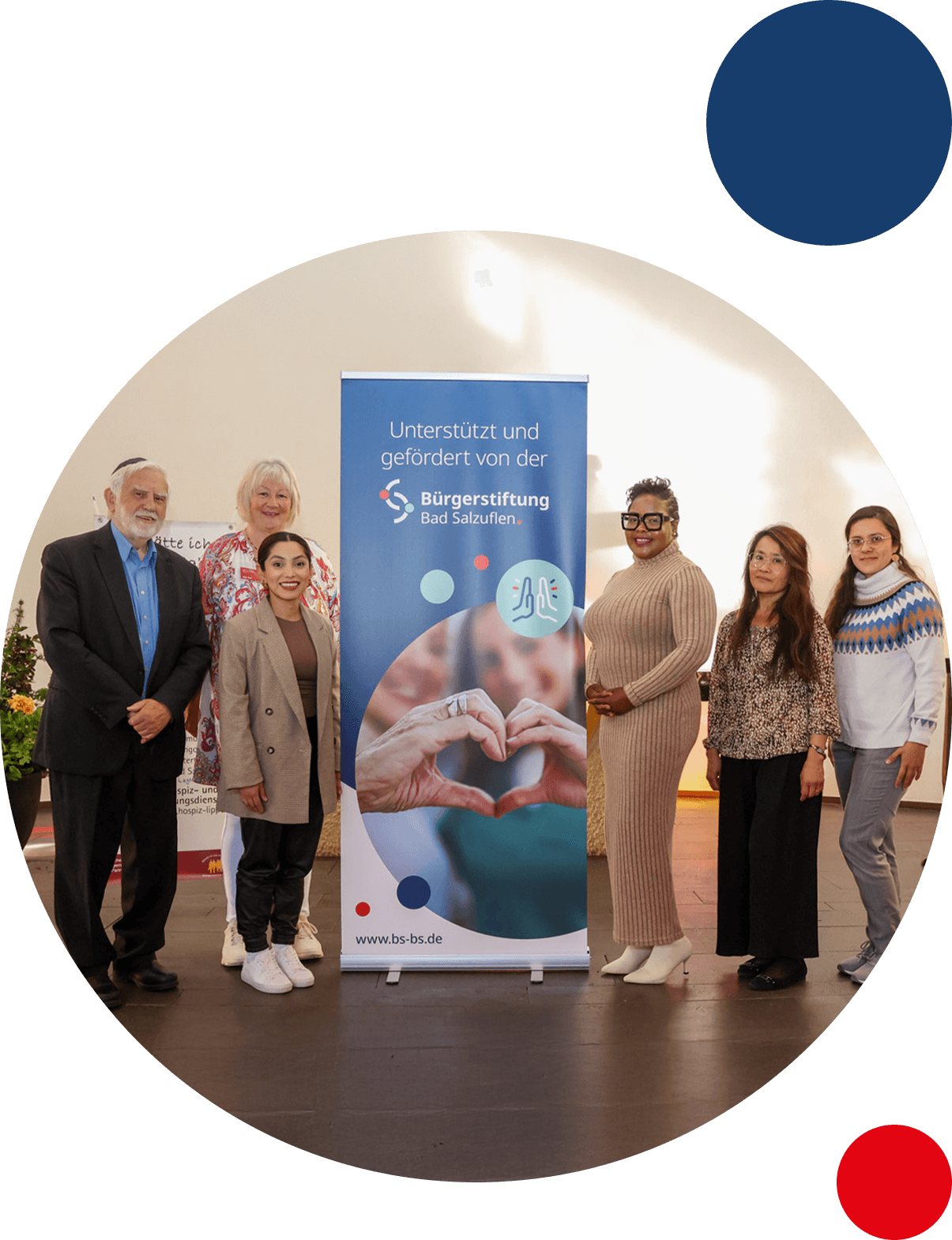 Sechs Personen mit verschiedenem kulturellen Hintergrund stehen neben einem Banner der Bürgerstiftung Bad Salzuflen